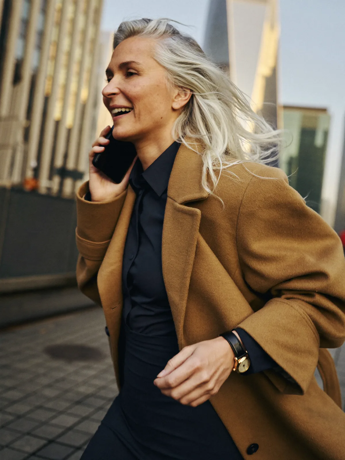 Woman entrepreneur walking through the city on her phone